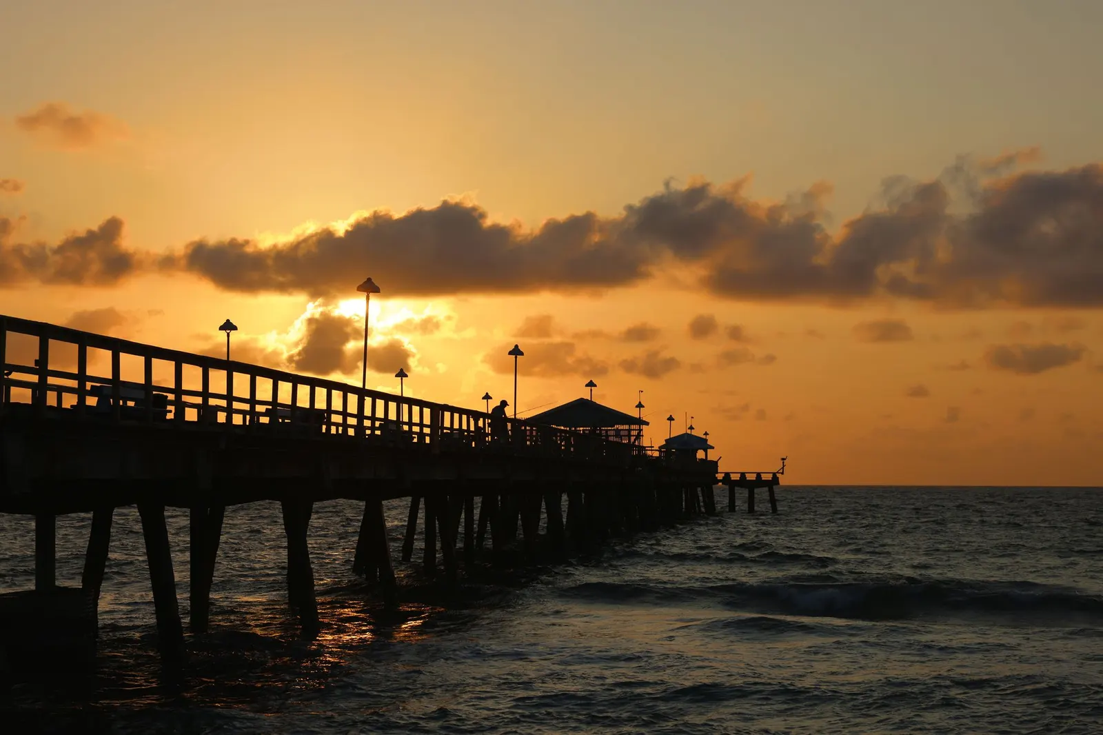 Fishing pier silhouetted against the sunrise