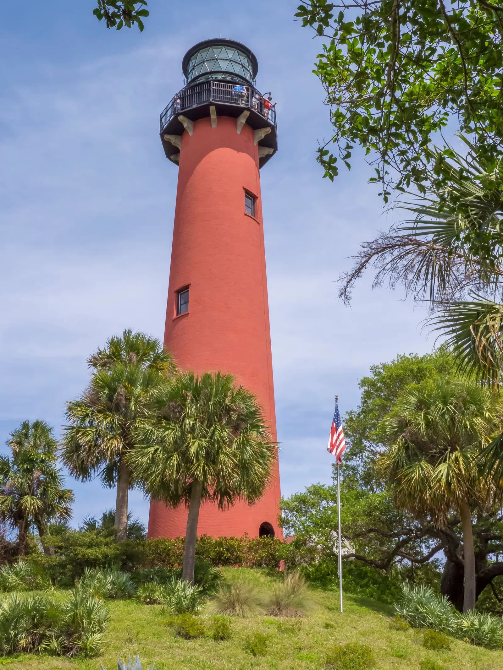 The red Jupiter Inlet Lighthouse among palm trees
