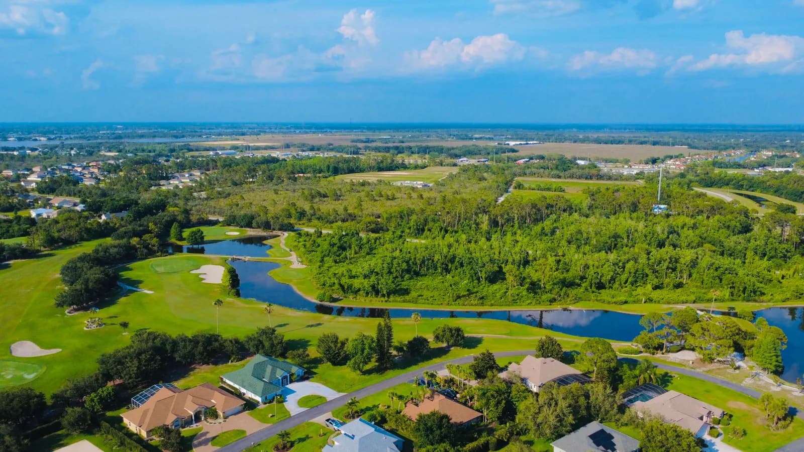 Aerial view of a golf community with lakes and green fairways