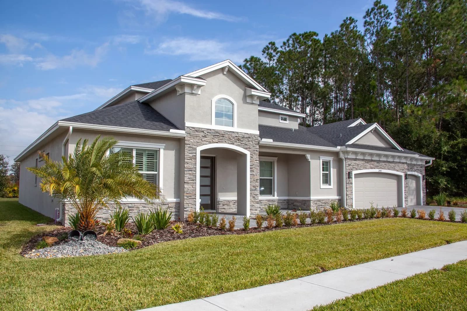 New single-family home with a paver driveway and fresh landscaping