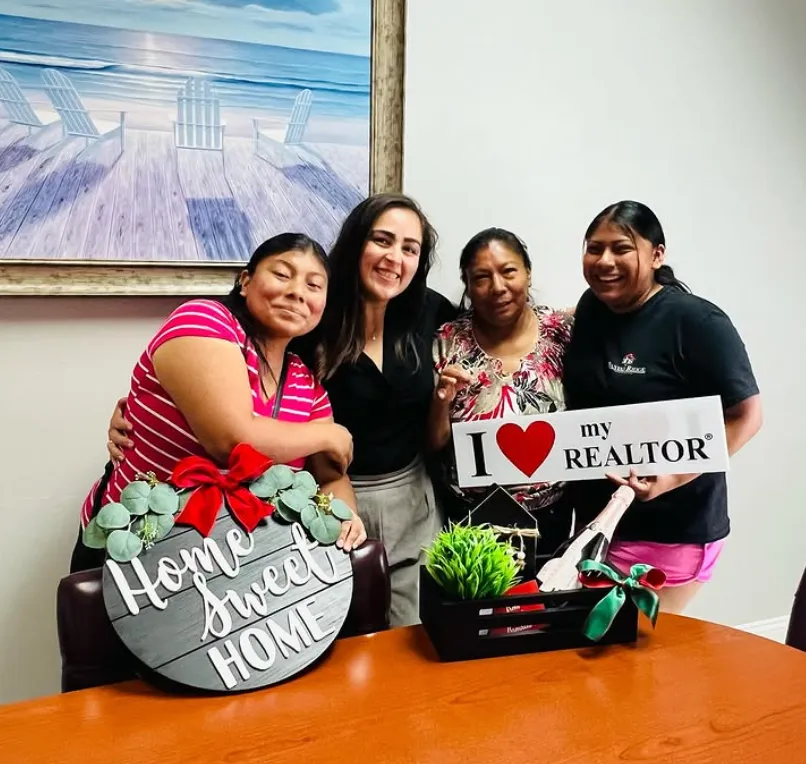 Gabriela with clients holding the Home Sweet Home sign and the closing-day gift box