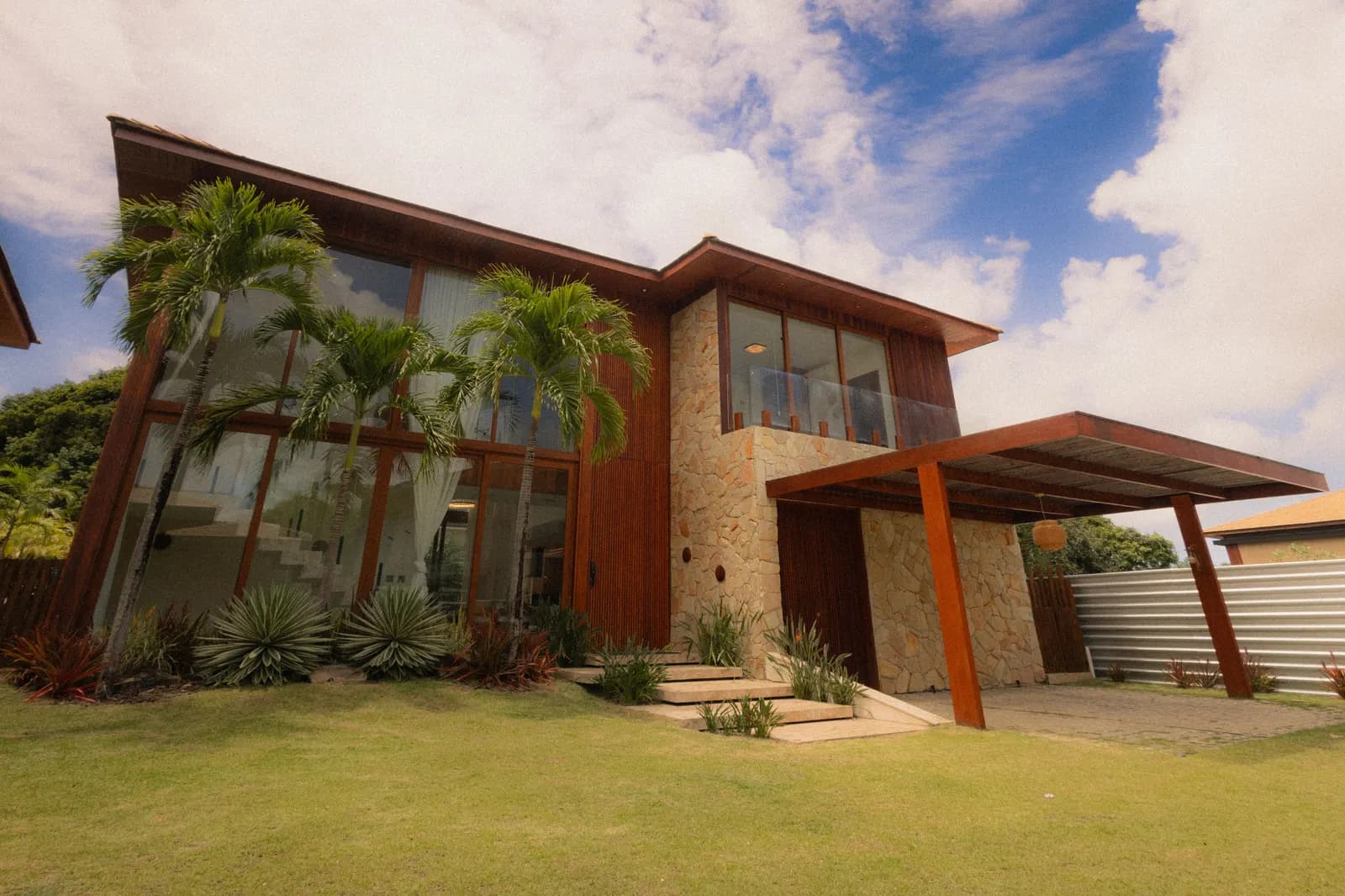 Modern two-story home with stone and wood details and a covered entrance